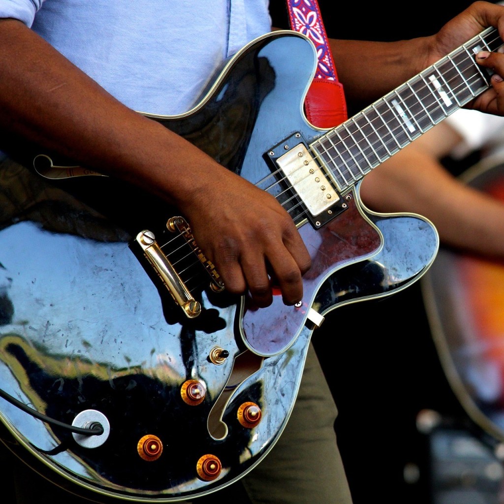 Close up picture of someone playing an electric guitar